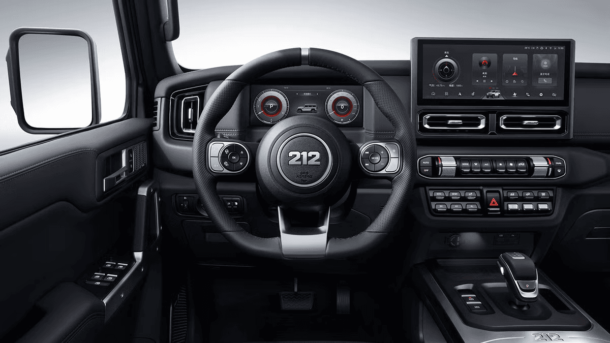 Interior de vehículo todoterreno con volante multifunción, pantallas digitales y controles físicos en la consola.
