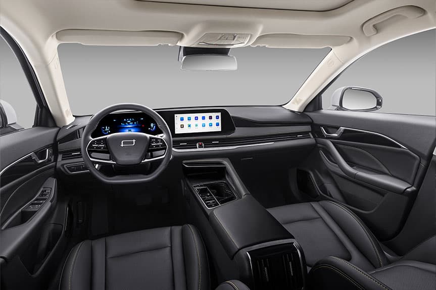 Interior de un coche moderno con asientos de cuero negro, volante multifunción y pantallas digitales.