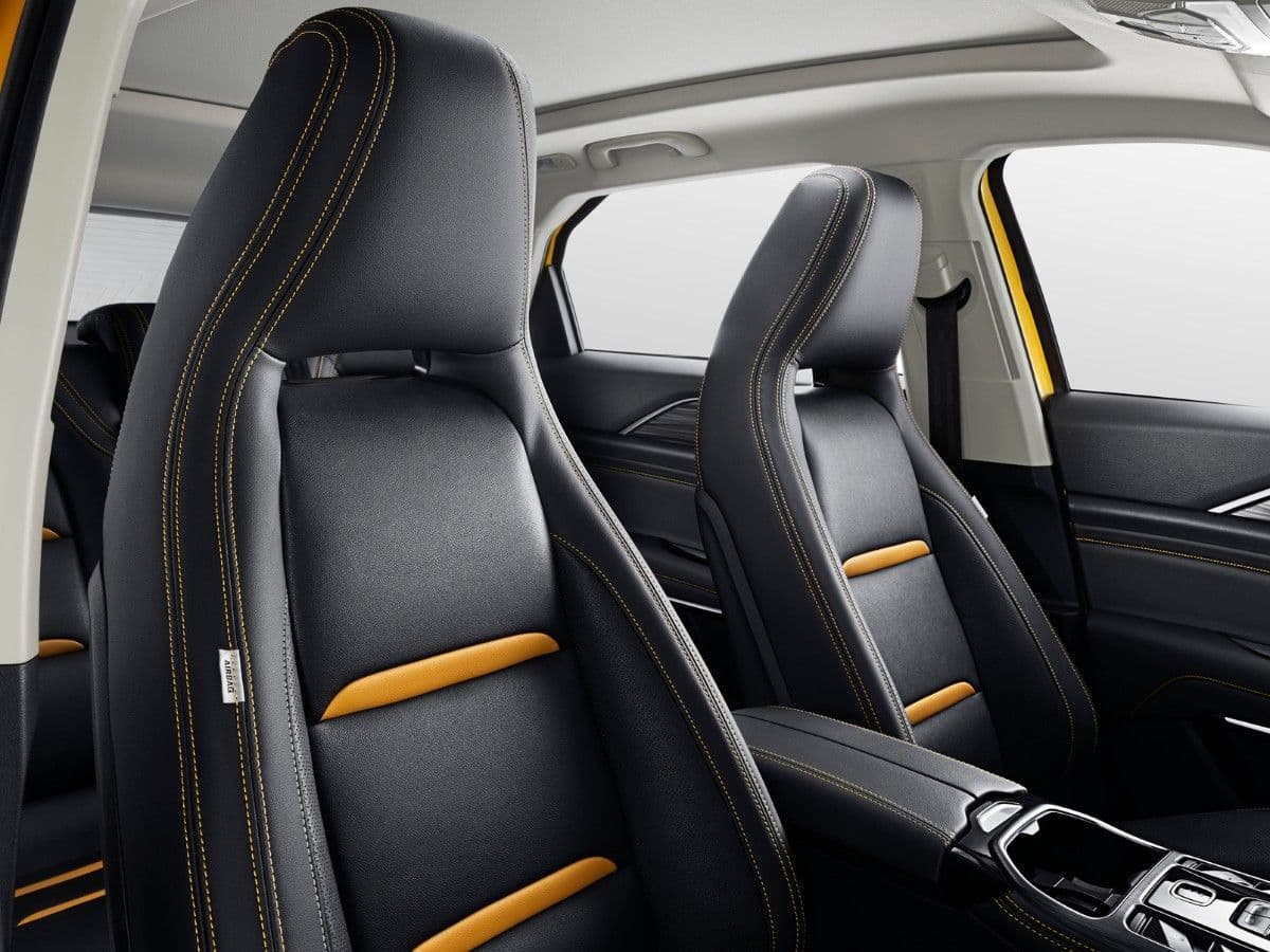 Asientos de cuero negro con costuras amarillas y detalles naranjas en el interior del coche.